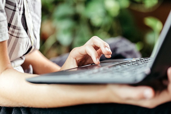 Close up of student outside using notebook computer