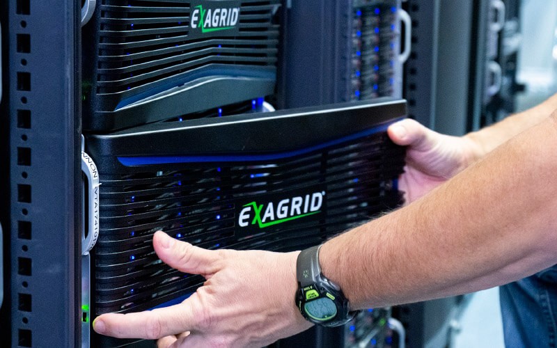 IT professional inserting disk on data storage