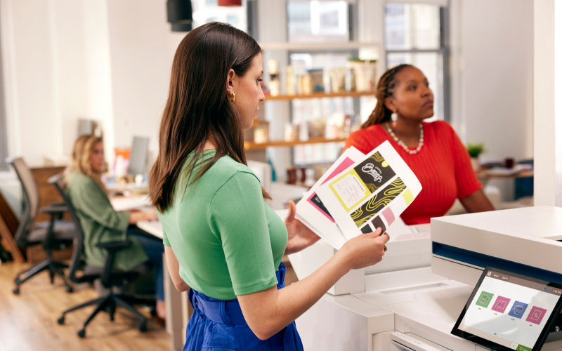 woman holding freshly printed papers from an HP printer