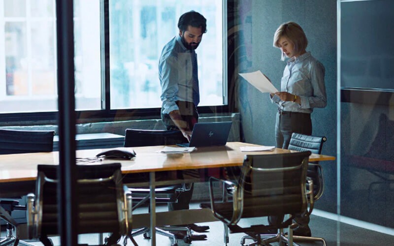 Teammates working together using a HP laptop