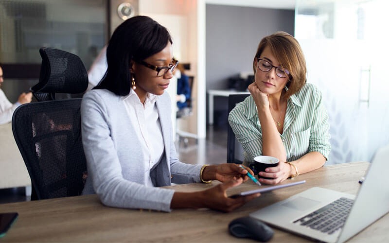Two woman working on technology 