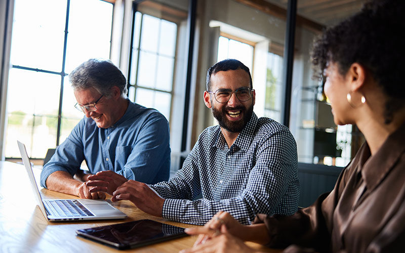 teammates-smiling-in-office-is2078176847