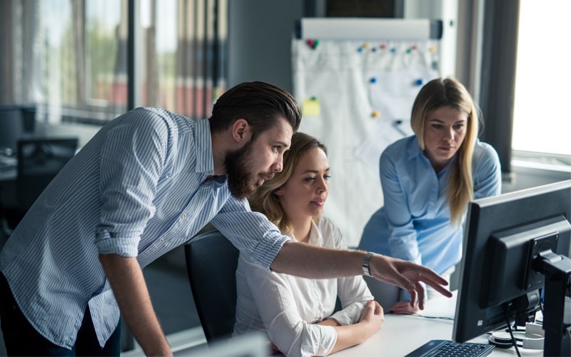 Team working off desktop computers in open concept office