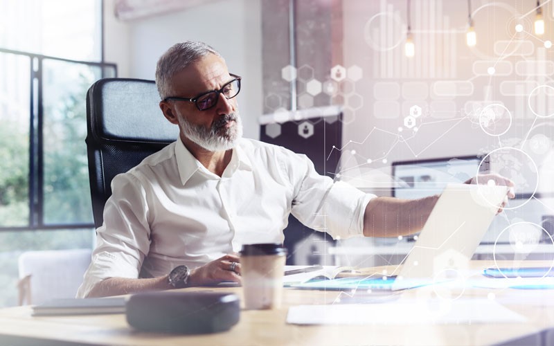 Man working on laptop with graphics displayed
