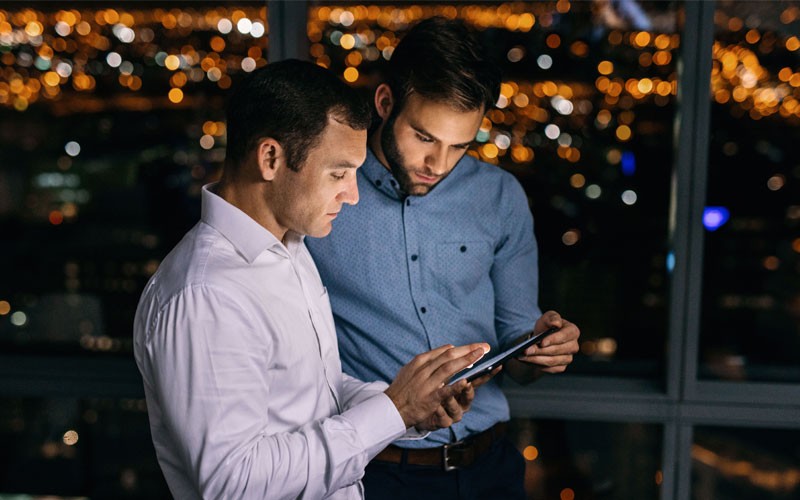 two-business-men-collaborating-over-tablet
