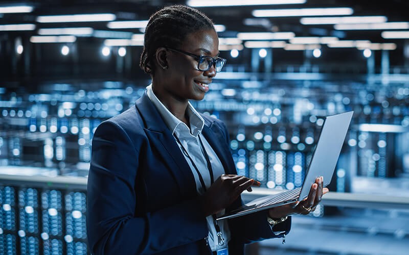 Woman holding her laptop inside data center