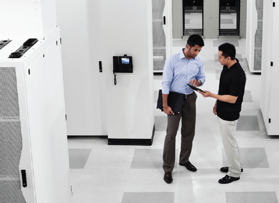 Two business men looking at tablet device in data center