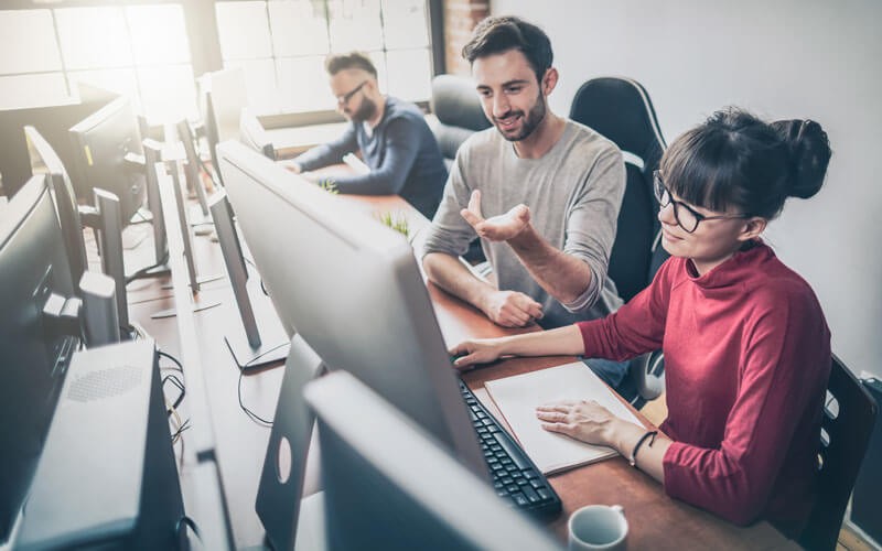 Coworkers collaborating at laptop device