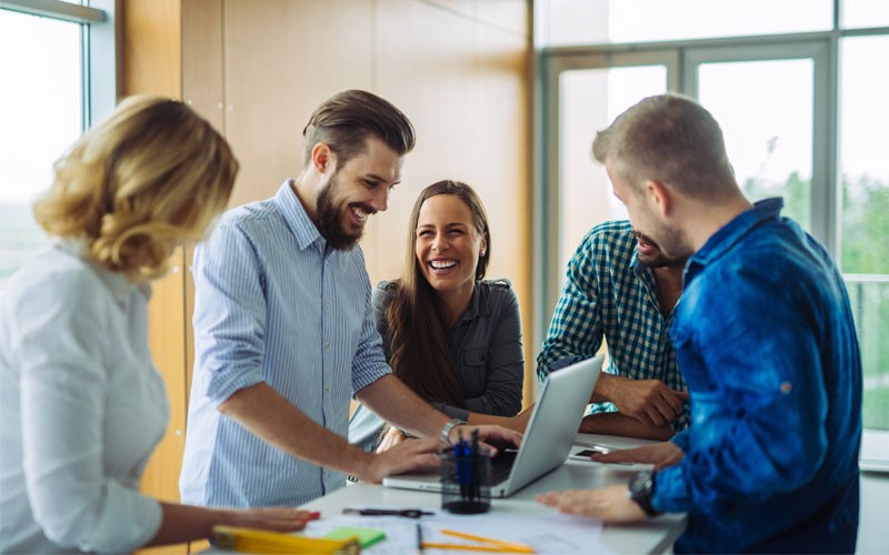 Collaboration of multiple employees surrounded by technology device