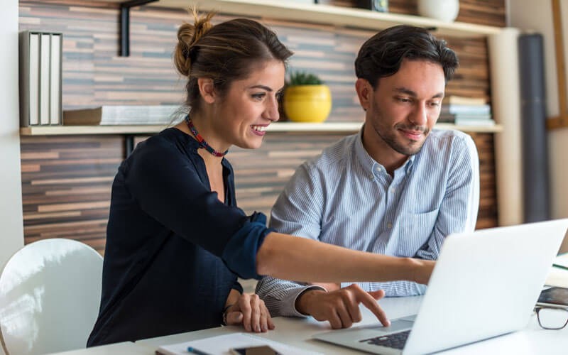 Two business professionals working on laptop computer