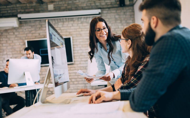 Three users smiling over desktop