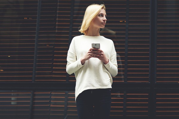Woman leaning against window Woman on phone leaning against glass window