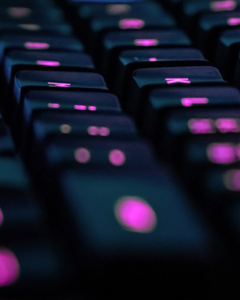 Next steps closeup of black keyboard with glowing pink letters