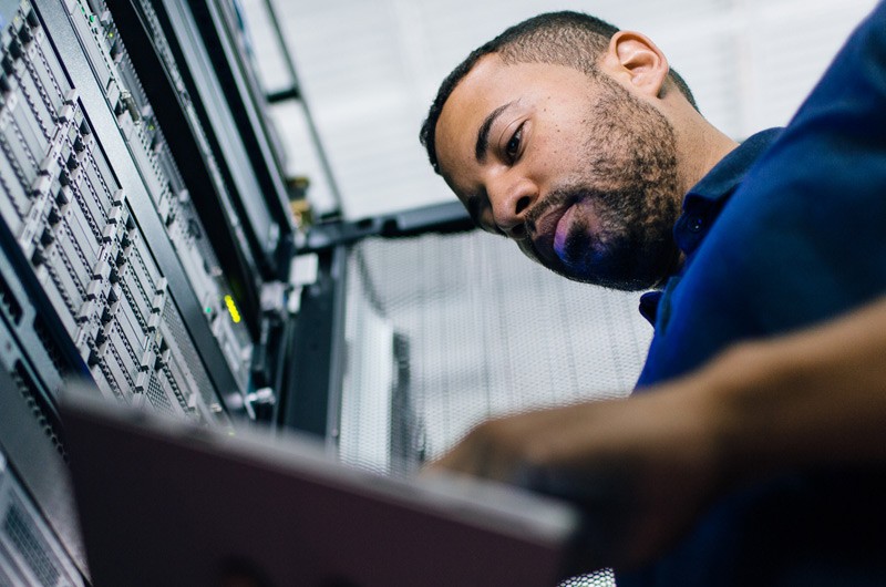 Man working on a tablet in a server room
